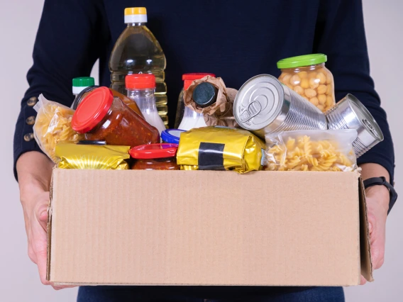 student holding box of pantry goods