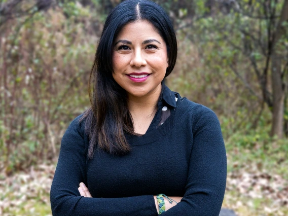 woman standing with arms crossed smiling and facing camera
